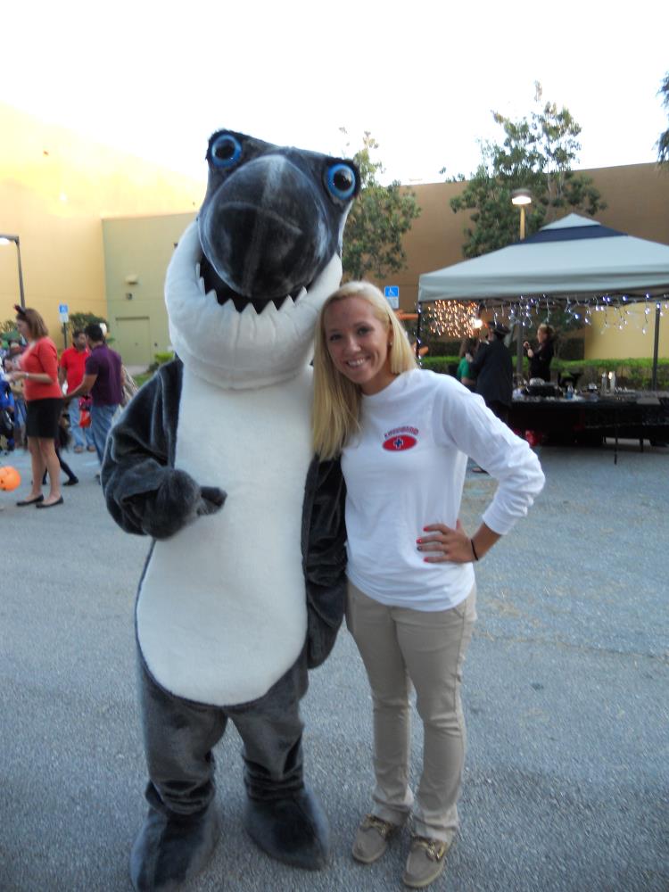 Person dressed in shark costume stands next to young woman